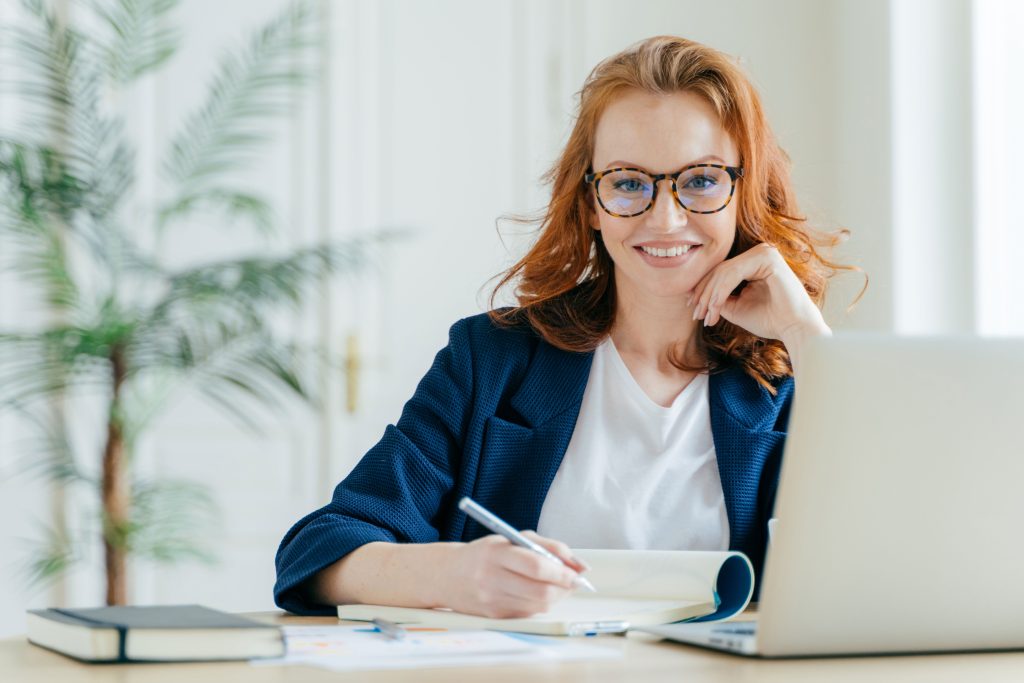 happy-successful-female-writes-checklist-in-notepa-2022-01-12-19-04-55-utc